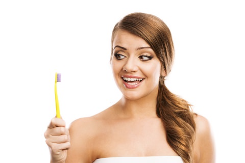 A woman looking at her toothbrush: Teeth Whitening review