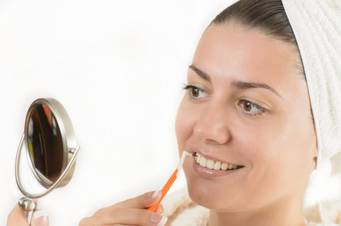 A lady using interdental pick