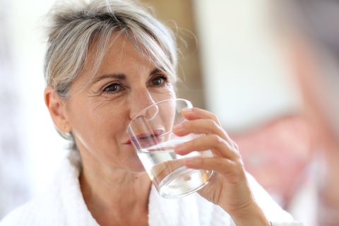 A lady drinking a glass of water