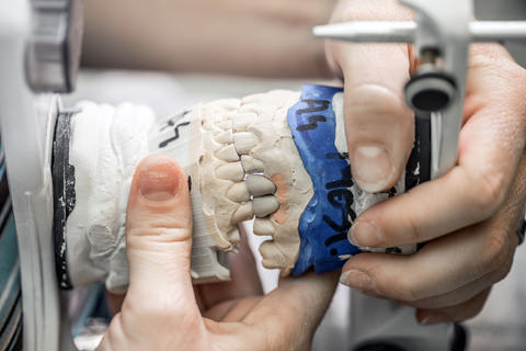 A dental technician making a set of dentures