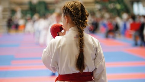 A girl using a mouthguard at a karate tournament