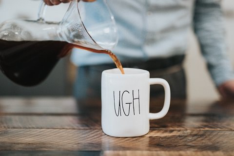 A coffee mug with the words UGH on it