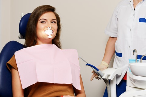 A lady at the dentist getting professional teeth whitening