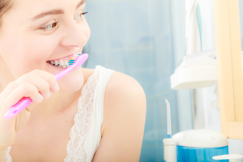 A lady brushing her teeth