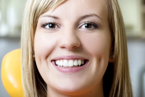 A woman smiling showing her teeth