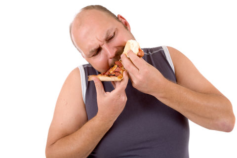 An overweight man eating pizza