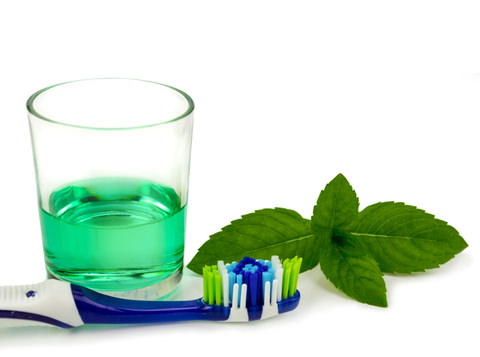 Mouthwash, a toothbrush and mint leaves