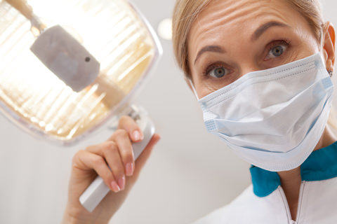 A dentist about to inspect a patients mouth