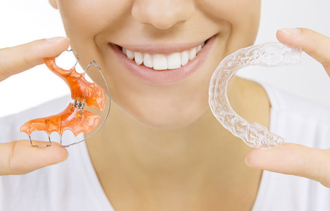 A lady holding up two forms of a retainer