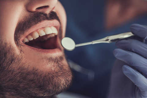 A man having his airway and mouth inspected by his dentist