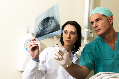 A specialist dentist looks at a X-ray