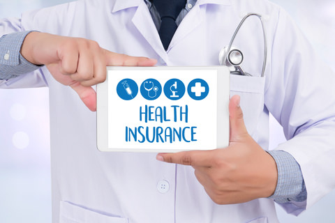 A man holding a card which says "health insurance"