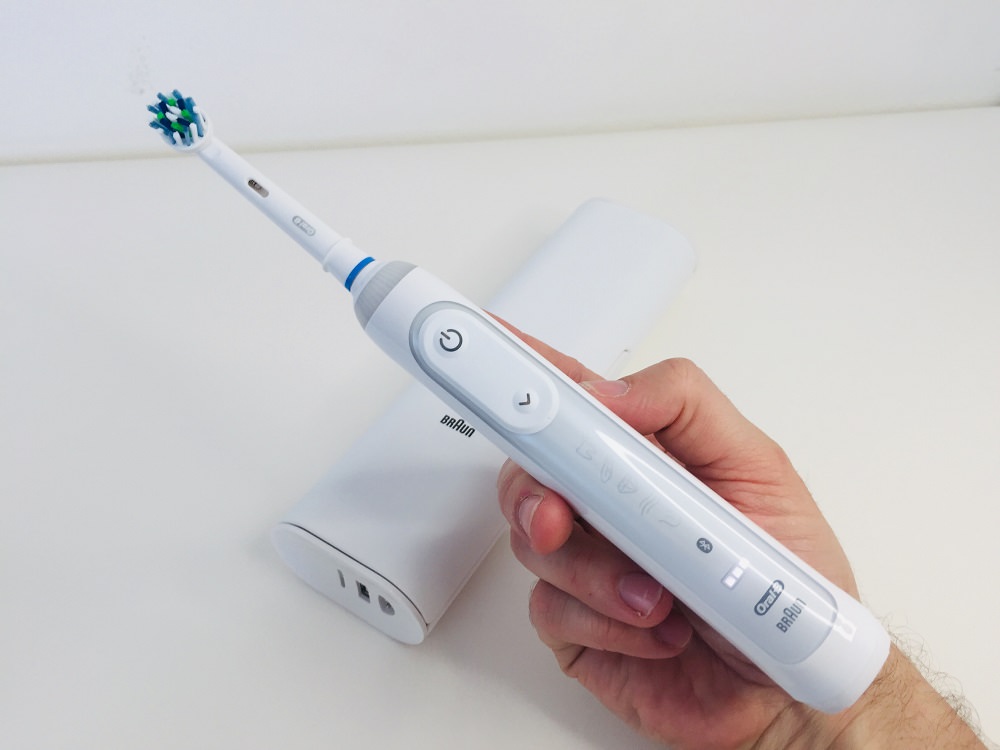 Holding the oral b genius 9000 electric toothbrush