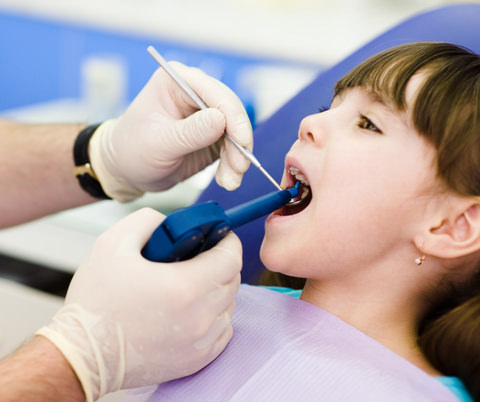 A dentist treating a young girl