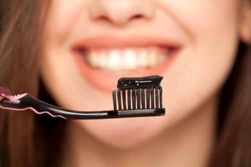 Charcoal toothpaste on a brush