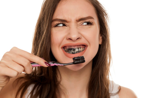 A lady using Charcoal Toothpaste