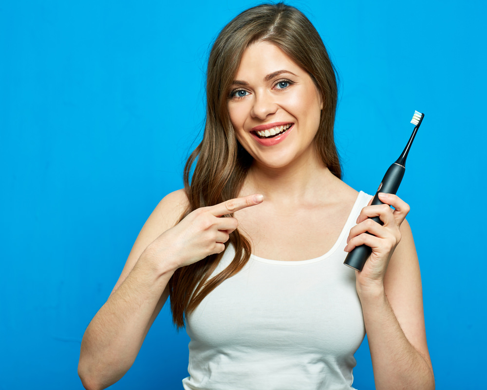 A lady with an electric toothbrush