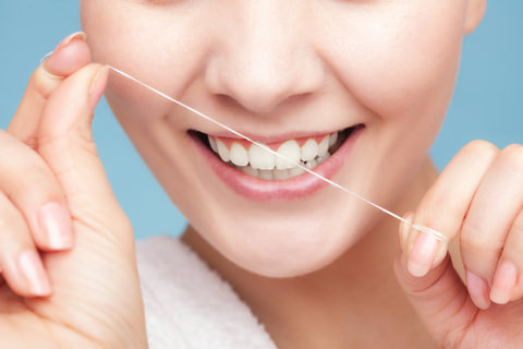 A lady showing how to use floss with your fingers