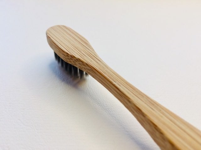 a side and back view of the colgate bamboo charcoal toothbrush