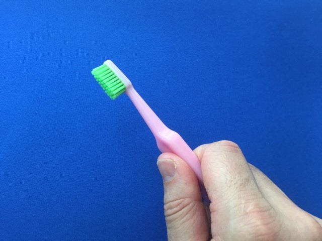 Holding the TePe Good™ Compact Toothbrush