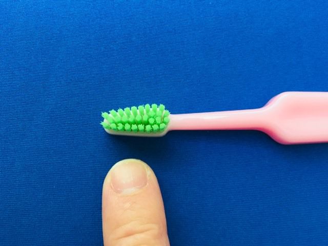 Comparing the TePe Good™ Compact Toothbrush bristle size to my finger