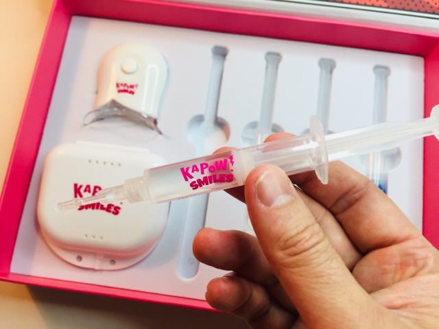 holding a kapow smiles whitening gel syringe