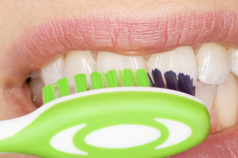 A lady brushing her teeth