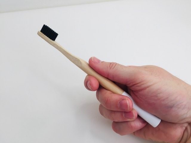 holding the kappi bamboo toothbrush in my hand