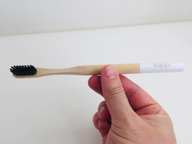 Holding the kappi bamboo toothbrush
