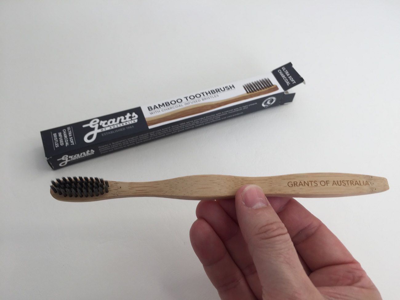 Holding the Grants bamboo charcoal toothbrush