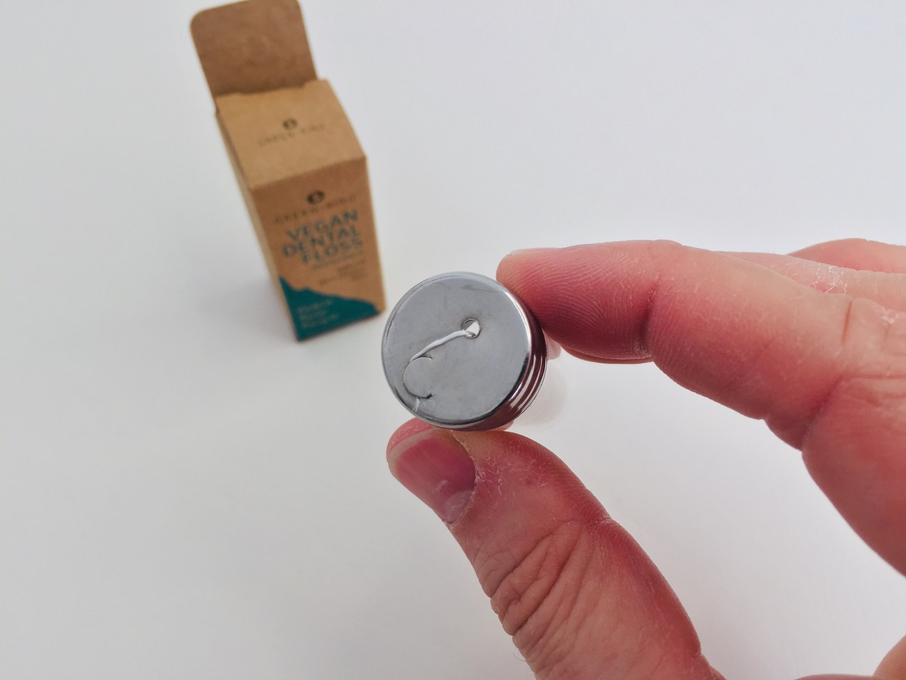 Looking at the refillable vegan floss lid by Green + Kind