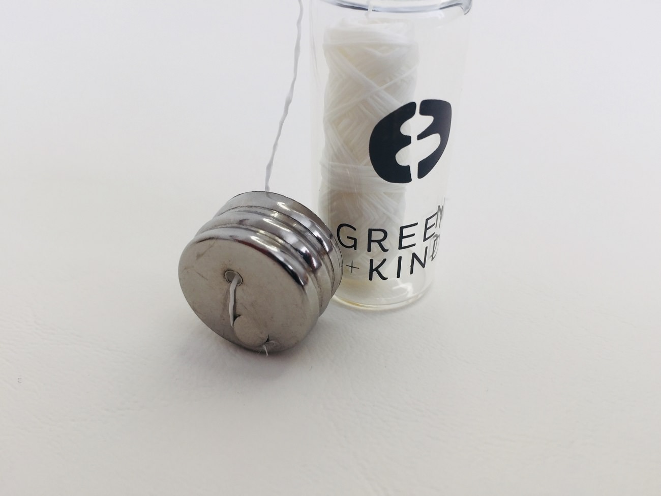 A closer look at Green + Kind glas vial and lid of their Vegan floss