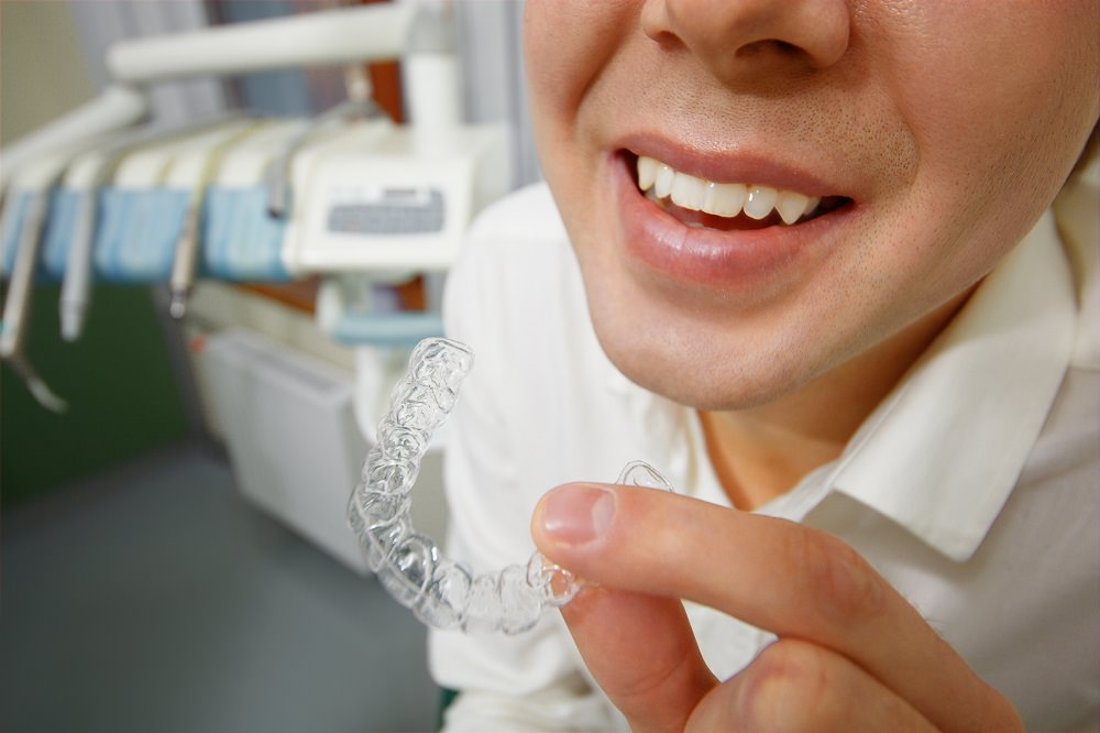 A dentist looking at a clear aligner