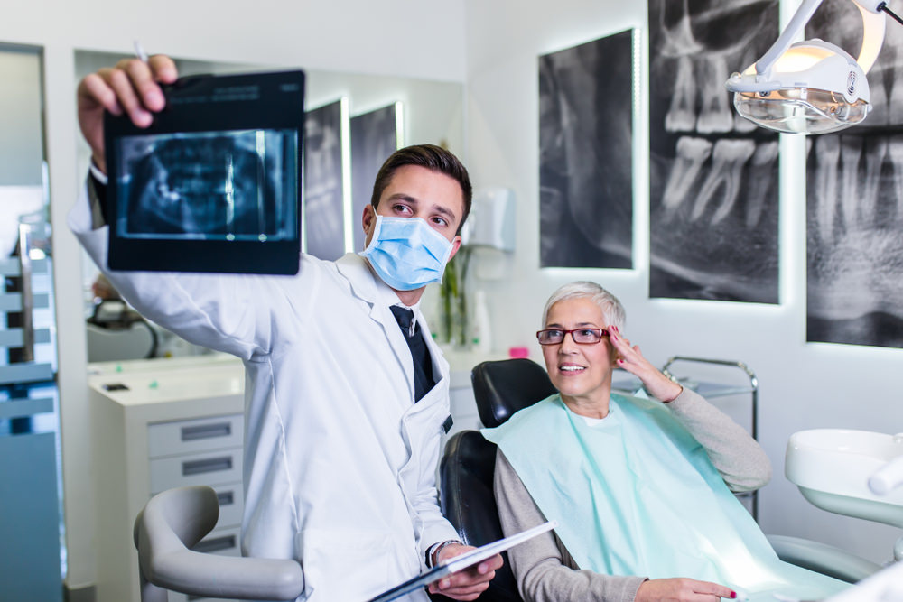 A dentist checking an X-Ray of a patient