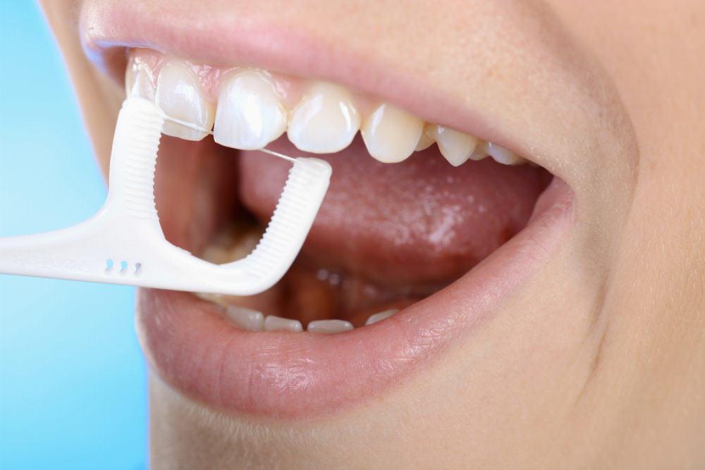 A person flossing as part of their dental hygiene routine