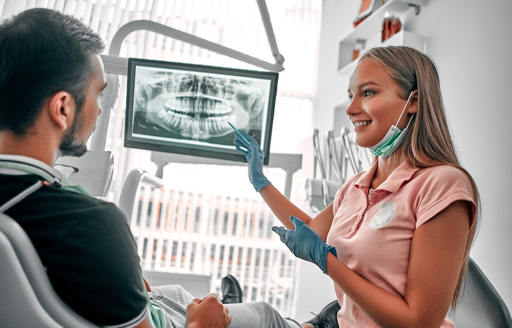 A dentist showing a patient their xray