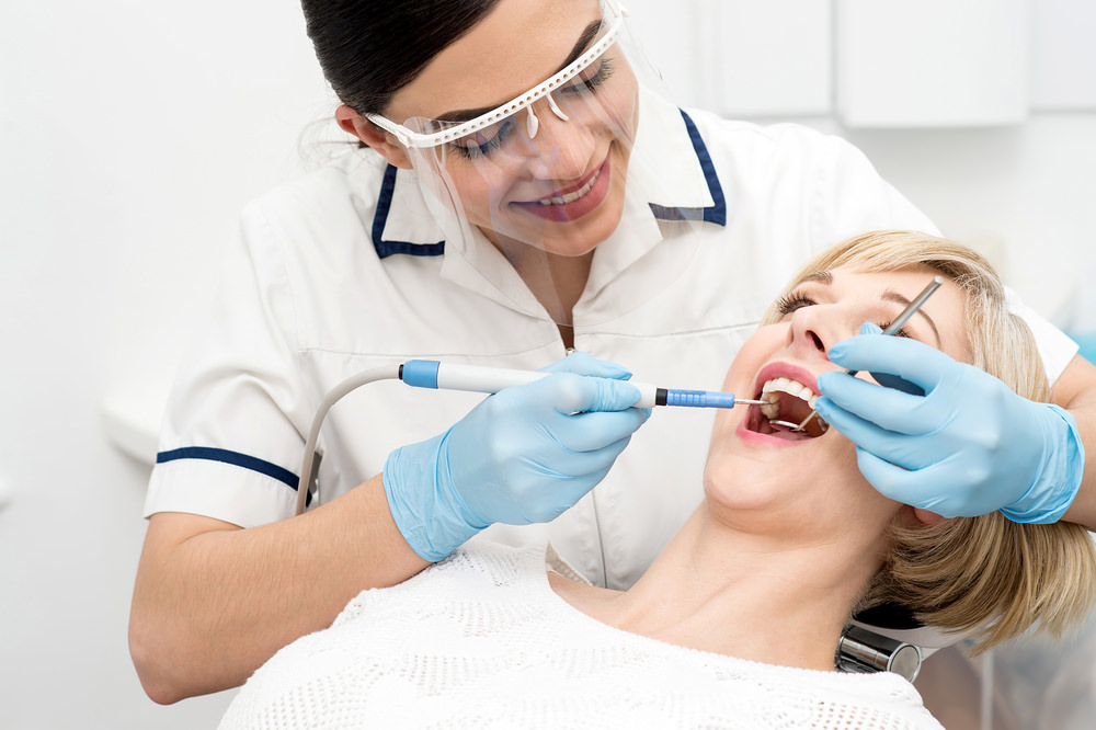 A lady having her teeth cleaned at the dentist