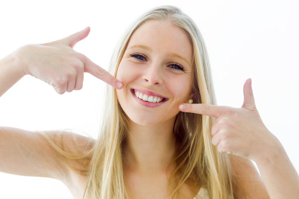 A student pointing to her teeth