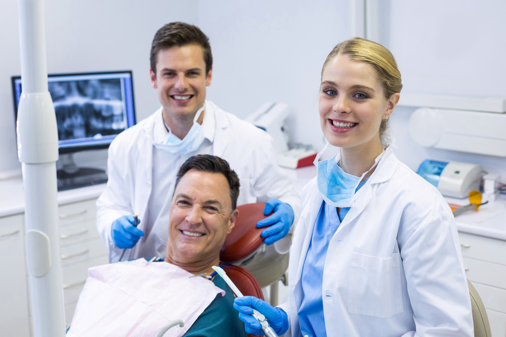 A dentist and Hygienist with their patient