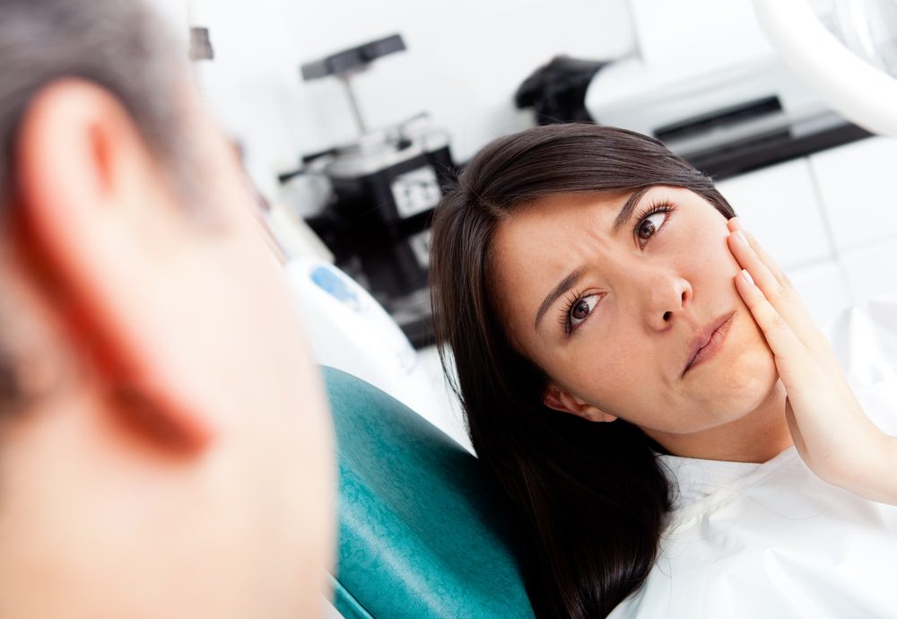 A woman in pain at the dentist Root Canal Treatment