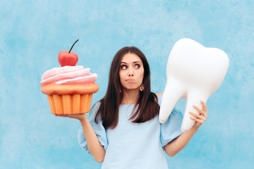 A lady with a cupcake and a tooth