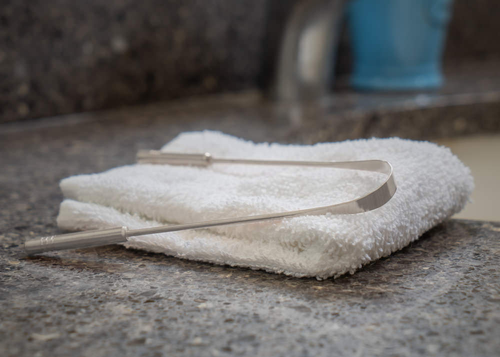 A tongue scraper on a small towel