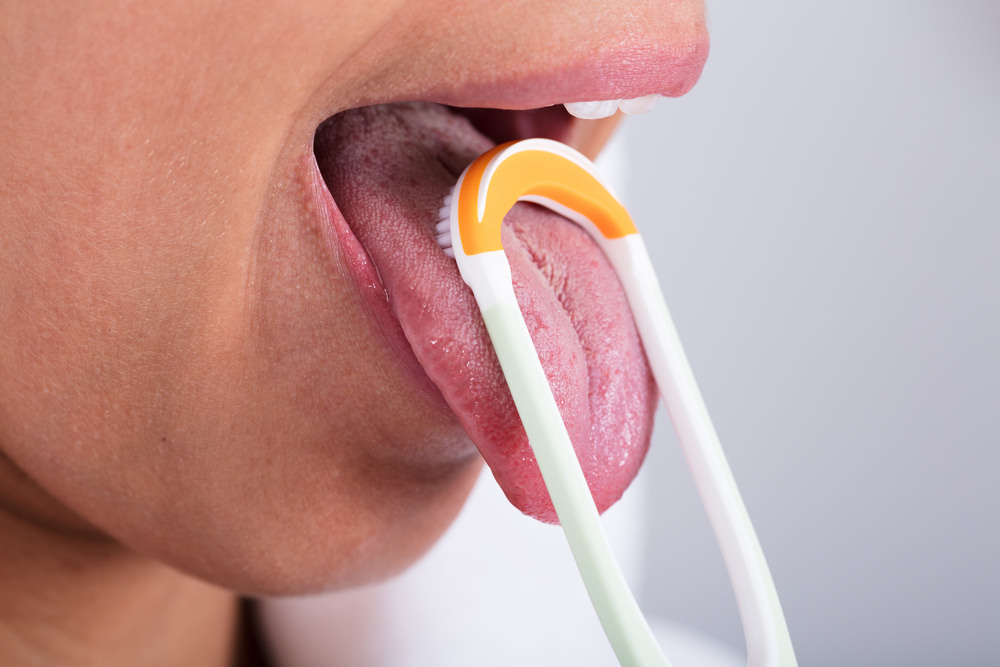 A lady testing out a tongue scraper