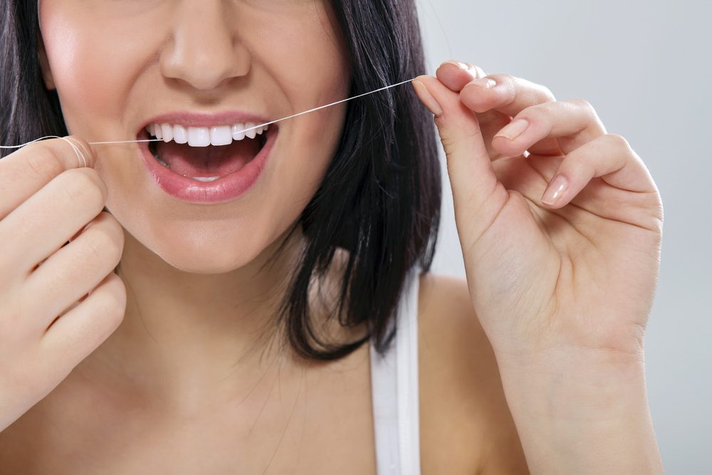 A lady using dental floss
