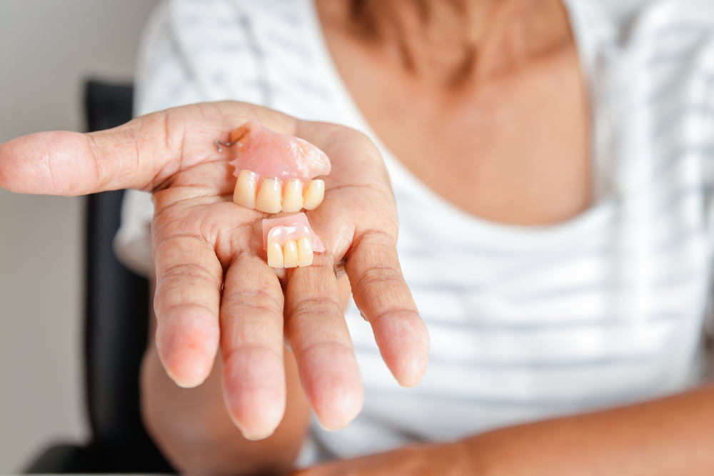 A lady holding partial dentures