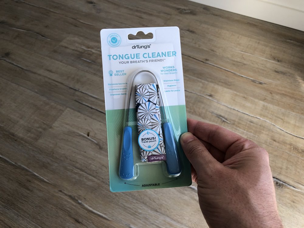 Holding a Dr Tungs Stainless Steel Tongue Cleaner
