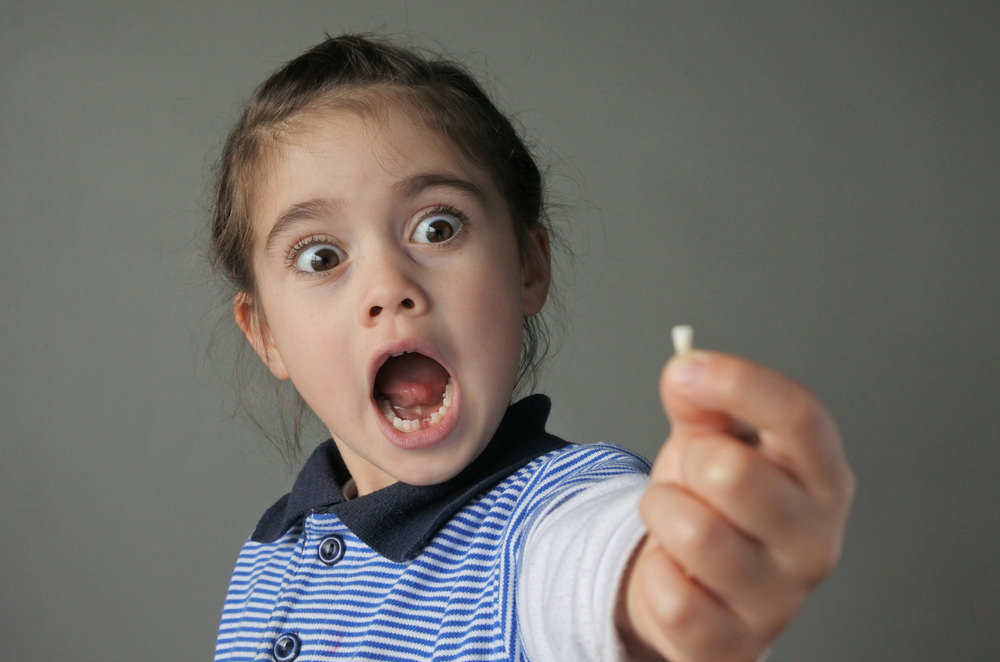 A surprised child with a pulled tooth