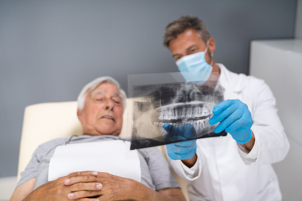 A patient looking at his x-ray with his dentist