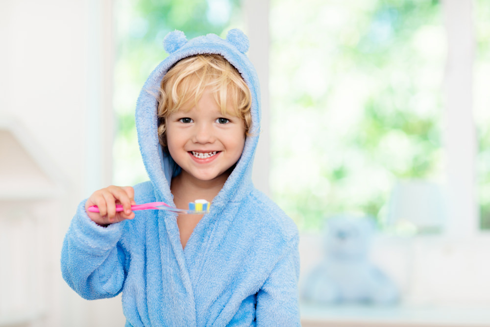 A young boy with a adult toothbrush