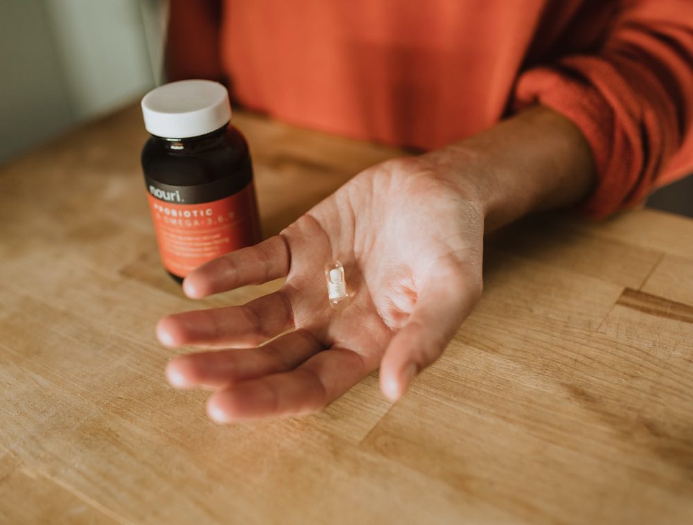 A lady holding a probiotic tablet